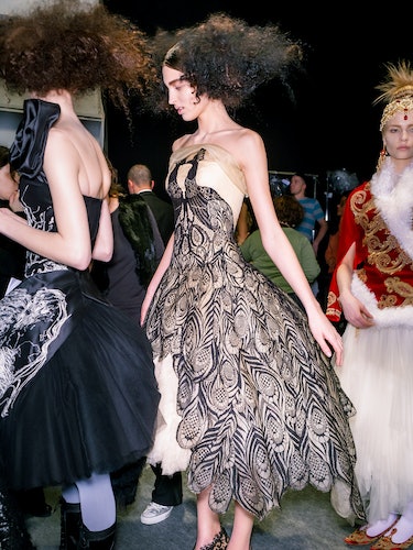 a model wearing a cream tulle evening dress with peacock lace appliqué during Alexander McQueen's fa...