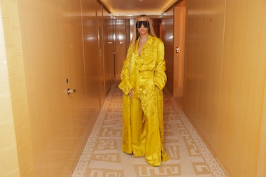 Beyoncé in a hallways wearing a bright yellow silky outfit