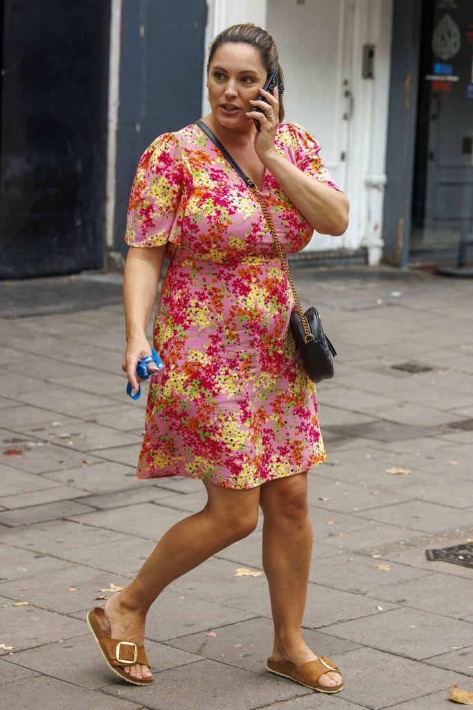 Kelly Brook wearing pink dress with orange green and yellow flowers