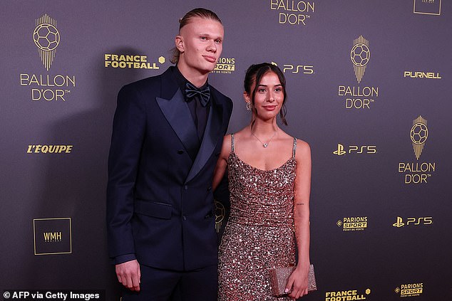 Erling Haaland poses in an all-navy tuxedo alongside his partner Isabel Haugseng Johansen